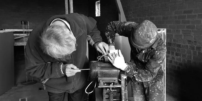 Two persons working on an engine
