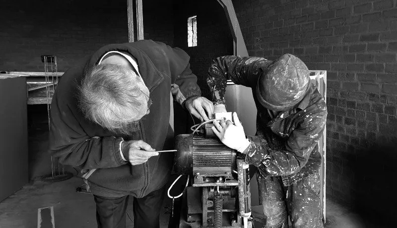 Two persons working on an engine