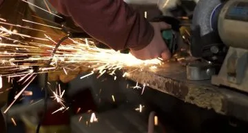 A person cutting metal with a chainsaw